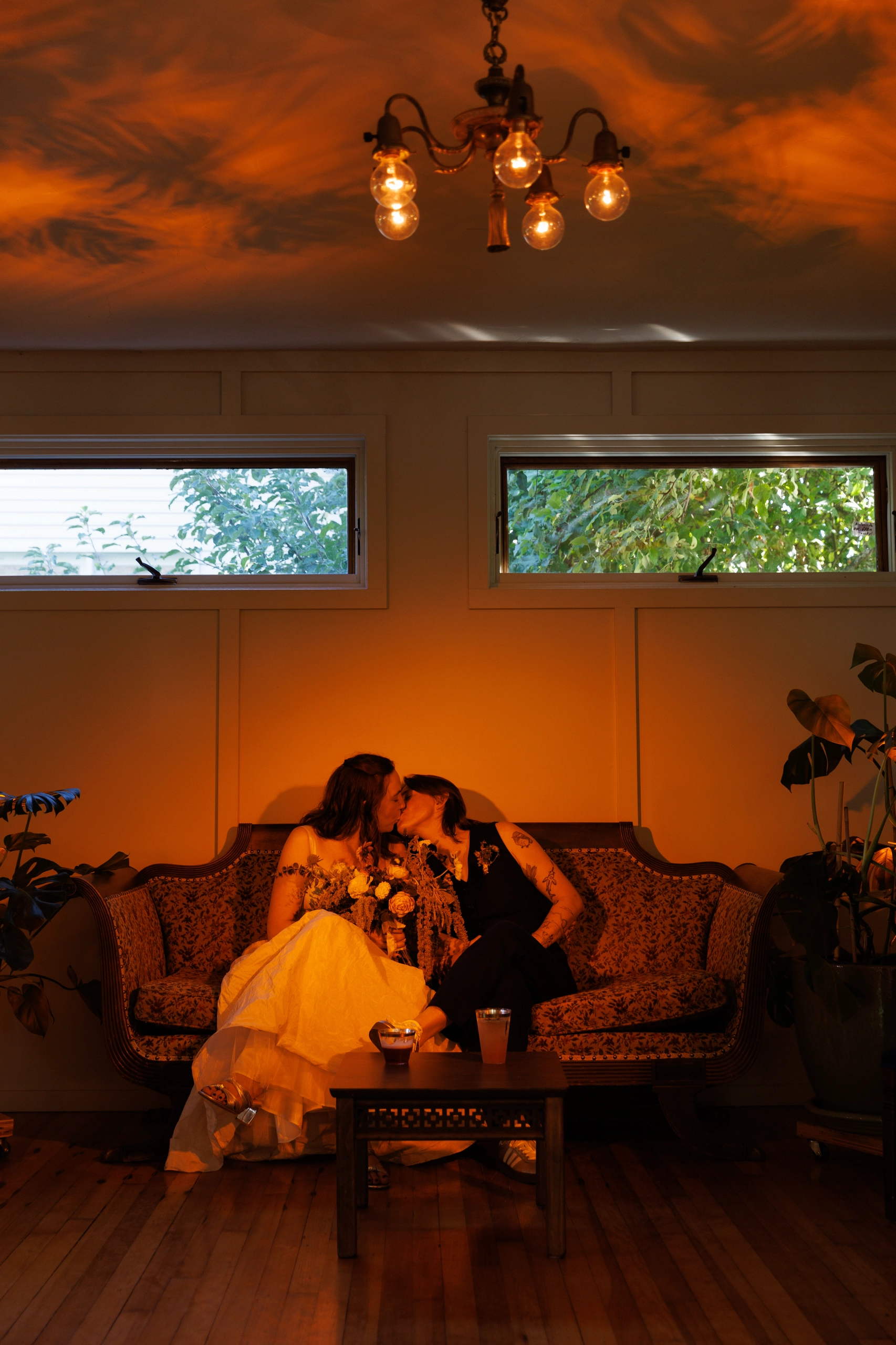 Newlyweds share a kiss under orange uplighting.