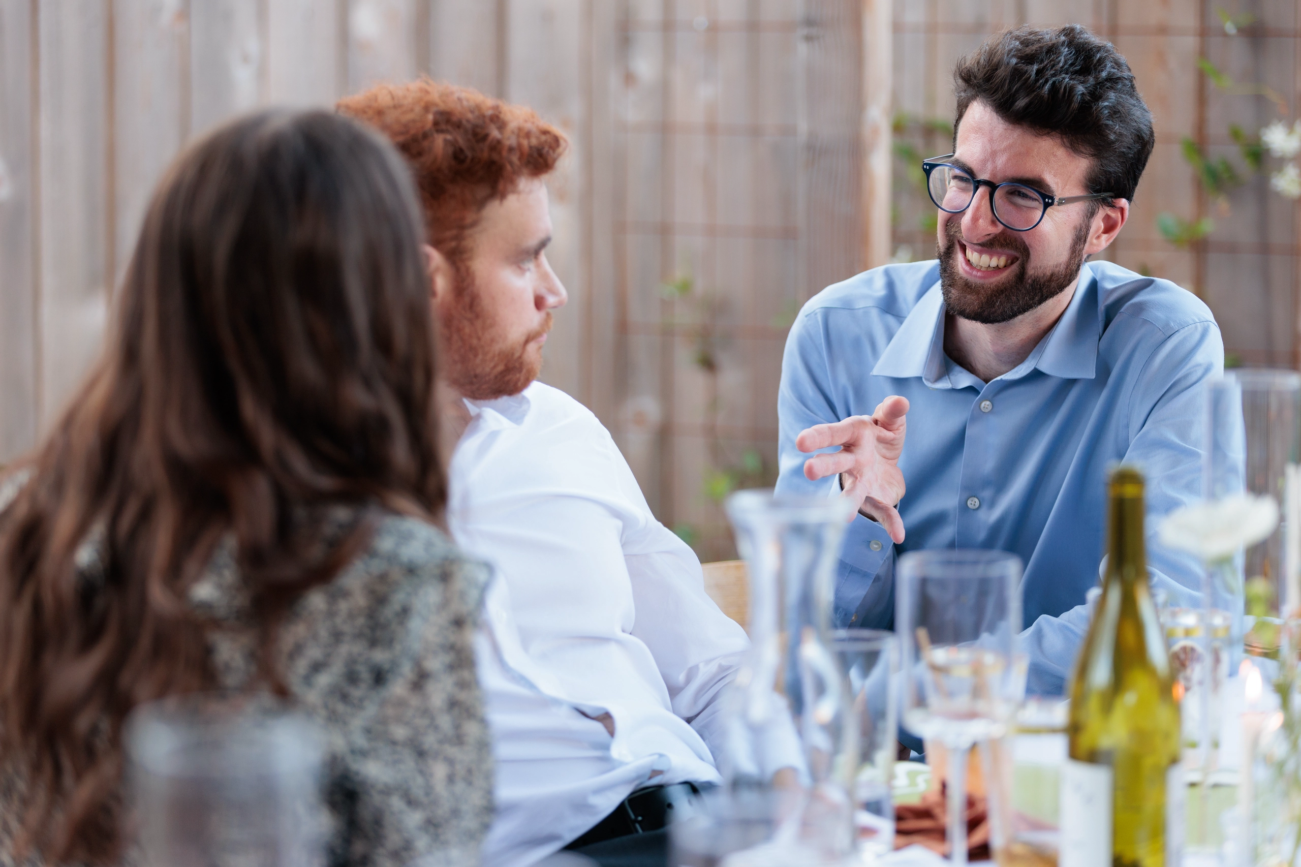 Wedding guests talk to each other at a table.
